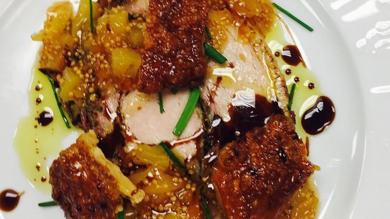 Porchetta and mustard fruit on white plate