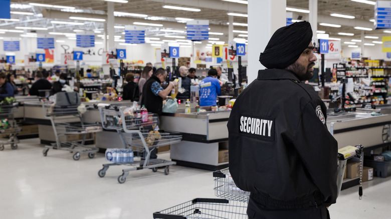 security guard standing in front of cash registers