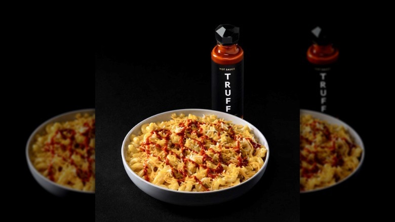 Noodles & Company Truff Mac in a bowl with a bottle of the hot sauce