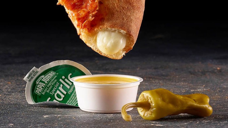 Pizza crust dipped in Papa John's garlic sauce