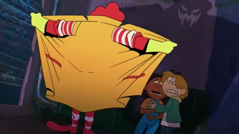 Person handing out a brown McDonald's bag