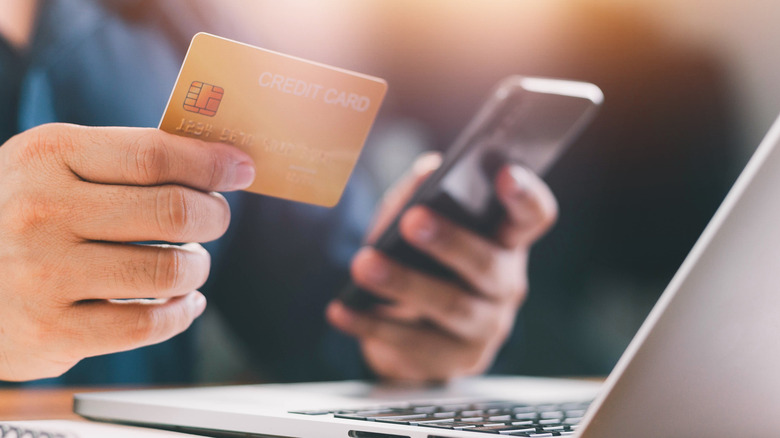 Male hands holding a credit card and a phone