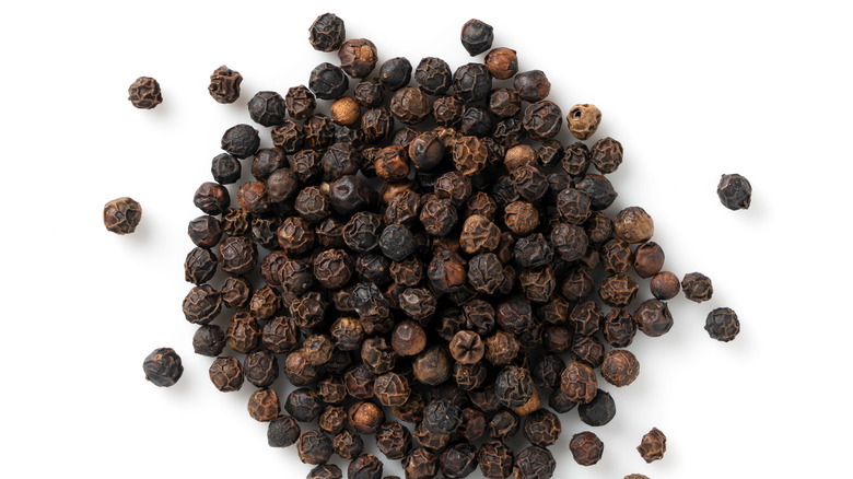 black peppercorns on white background