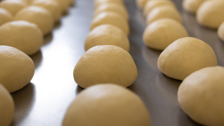 mounds of dough resting on metal table