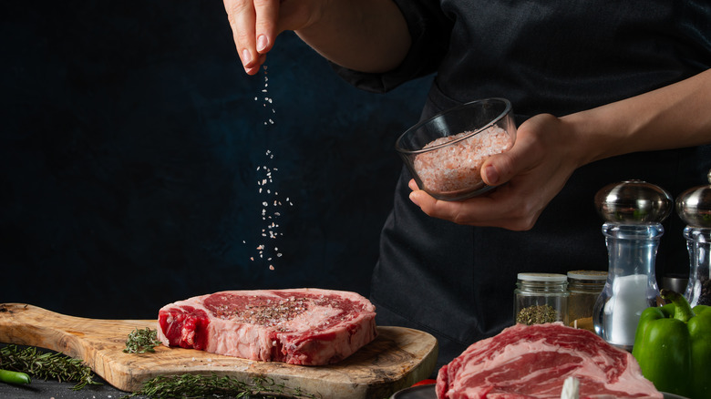 sprinkling salt on steak