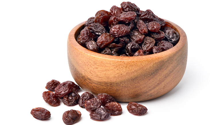 A wooden bowl full of raisins