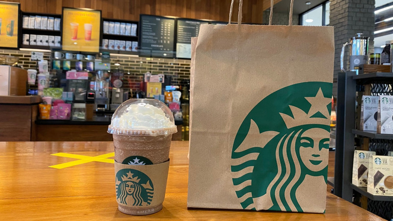 Starbucks Frappuccino and paper bag on table