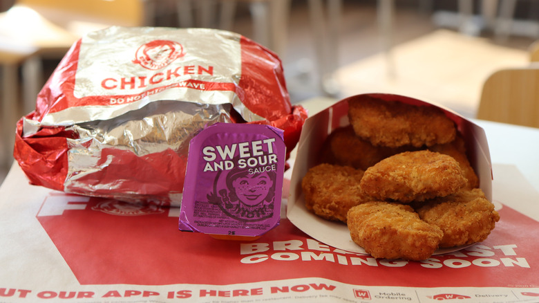 Chicken nuggets, a sandwich, and dipping sauce from wendy's
