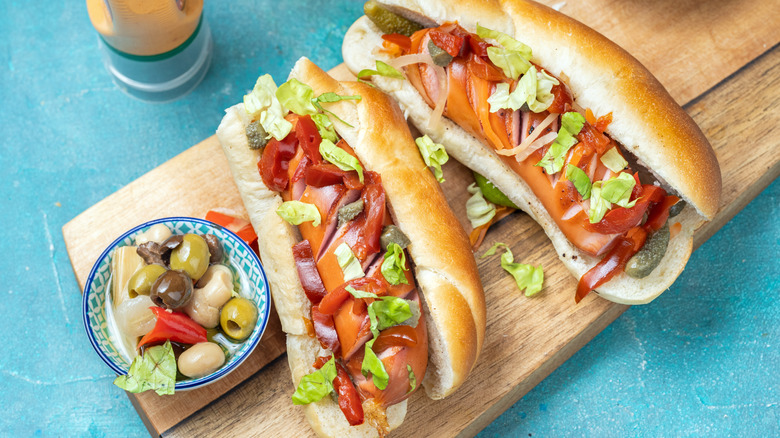 Two spiral-cut hot dogs with toppings on cutting board