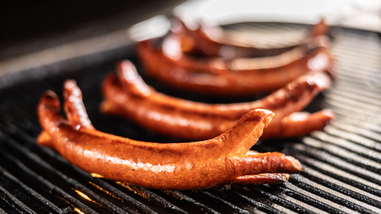 Four split hot dogs on grill