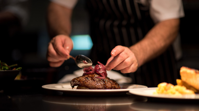 Chef plating steak dish