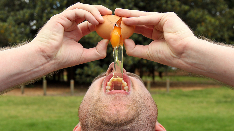 Man eating raw egg