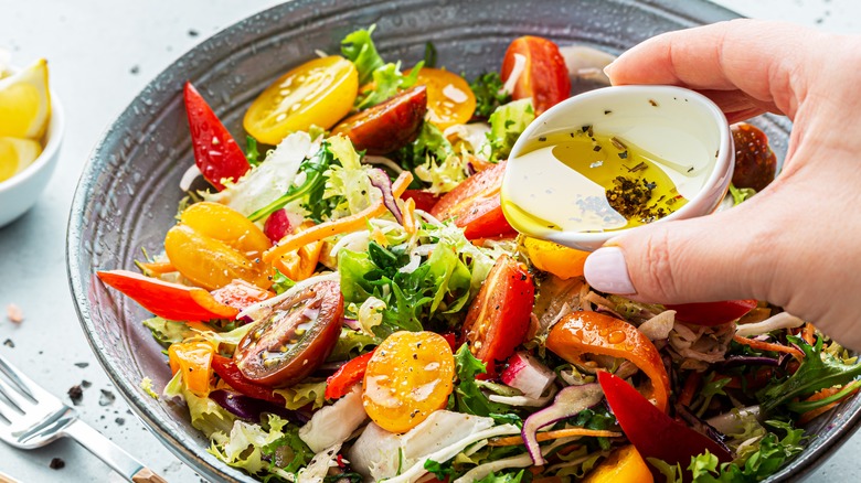 salad with dressing being poured on