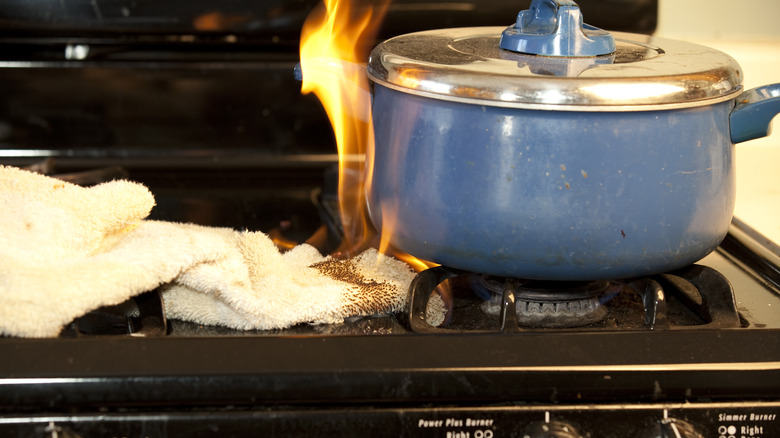 Stove fire with pot and towels