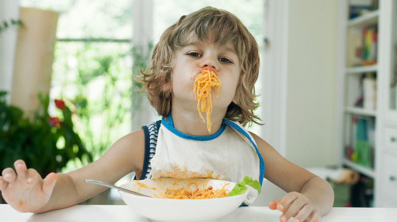 Boy eating pasta messily