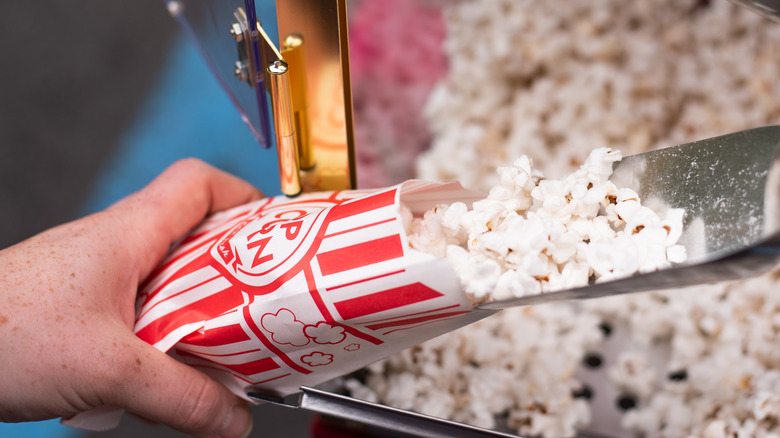 Hands filling movie theater popcorn