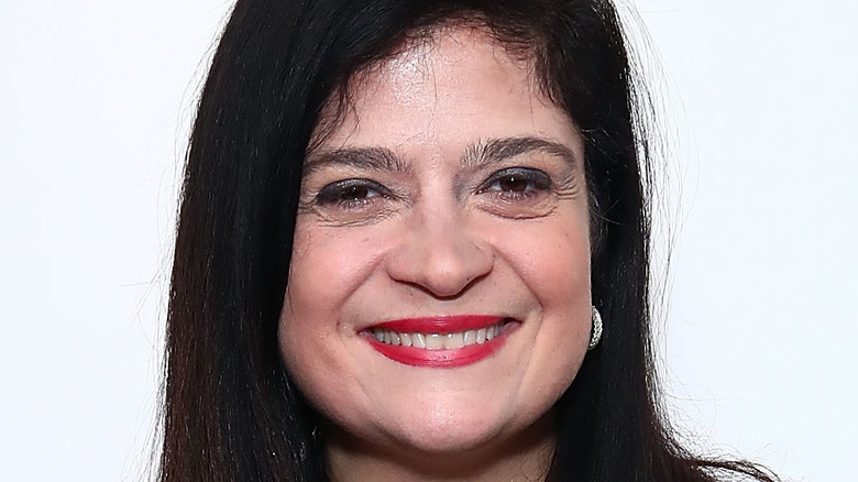 Alex Guarnaschelli wearing red lipstick and smiling