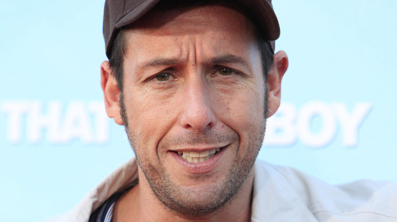 Adam Sandler wearing a baseball cap 