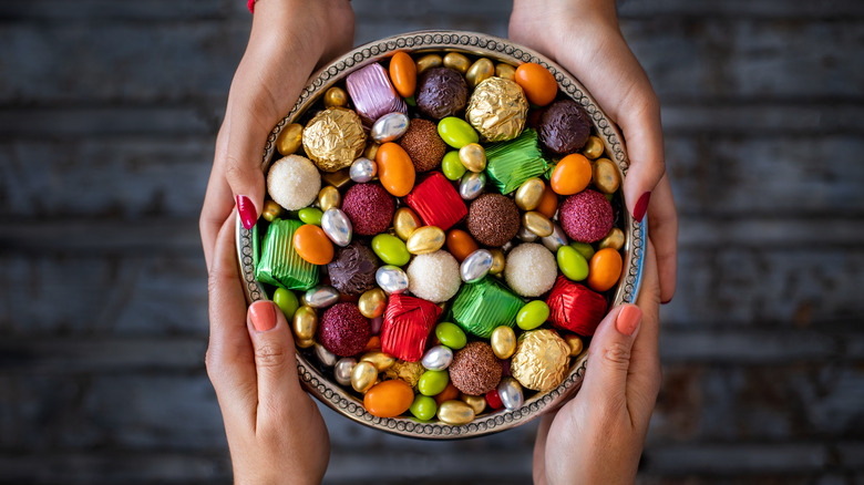 hands holding candy bowl