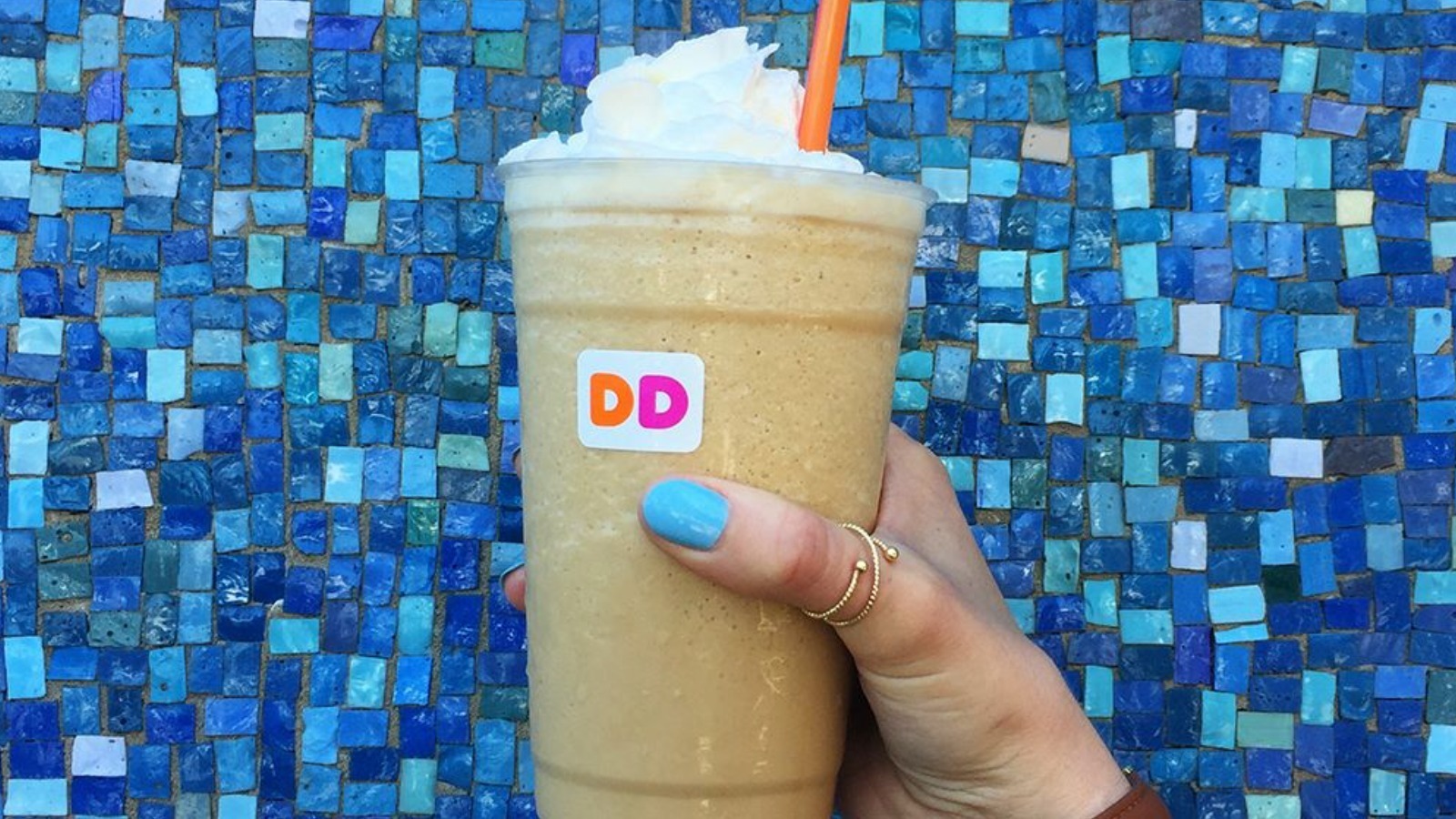 Person holding Dunkin Donuts frozen coffee with coffee syrup