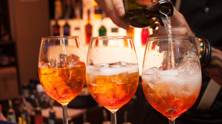 Pouring wine into glasses with ice