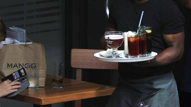 Waiter carrying tray of drinks