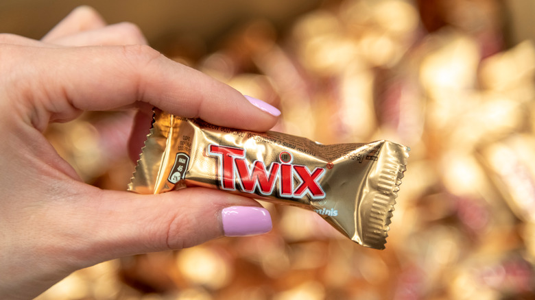 A mini Twix bar held in the air