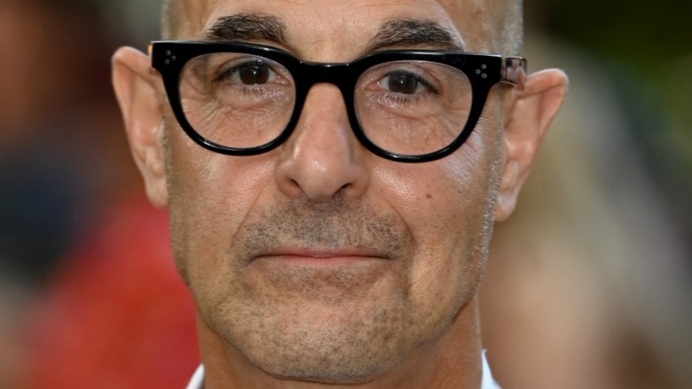 Stanley Tucci with glasses and slight smile