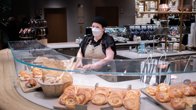 Starbucks employee in front of pastries