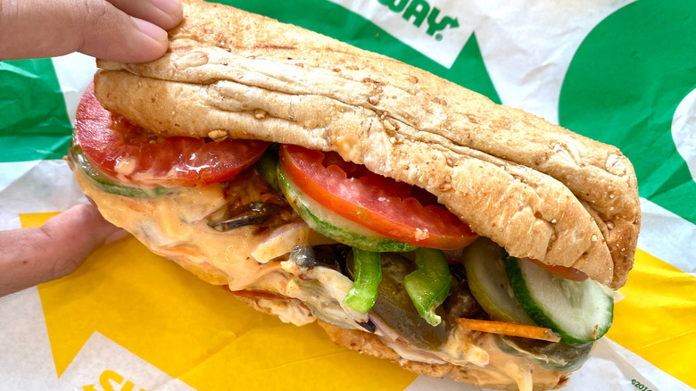 Subway sandwich filled with tomato, cucumber and sauce