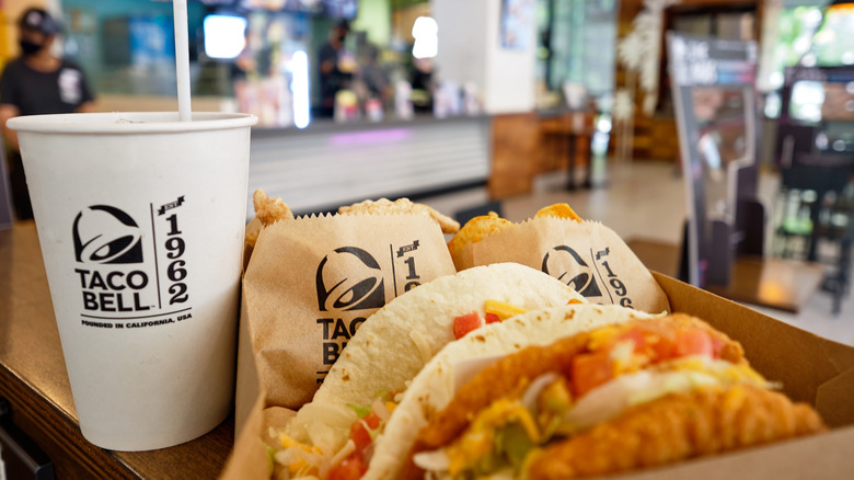 A Taco Bell meal with two tacos, sides and a beverage