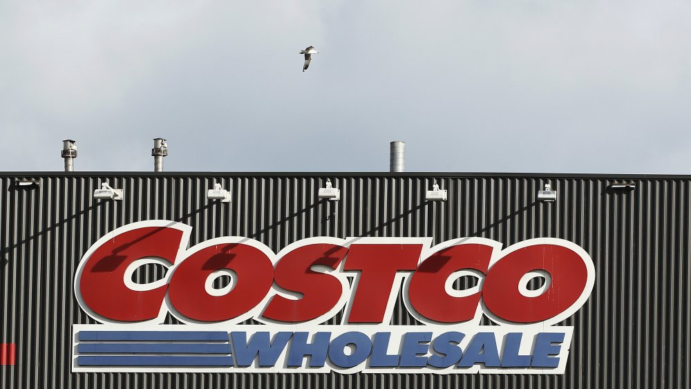 A seagull flies over a Costco Wholesale sign