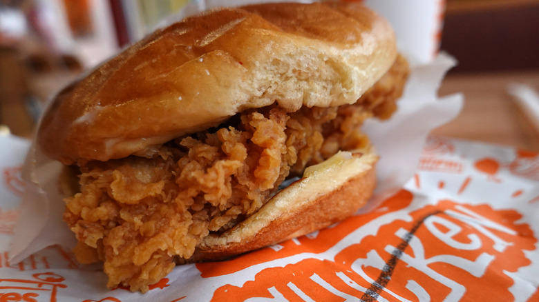 A closeup of Popeyes chicken sandwich on paper