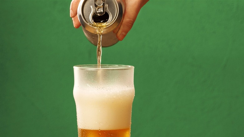 A can of beer being poured into a glass