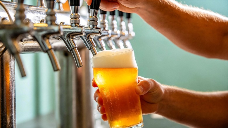 Draft beer being poured from a tap.