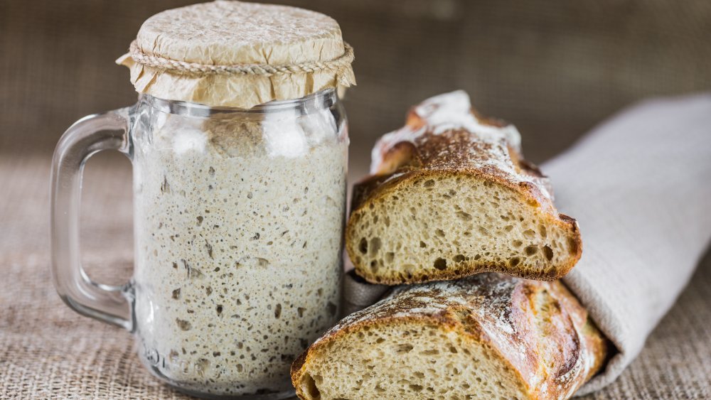 sourdough starter in jar with sourdough bread