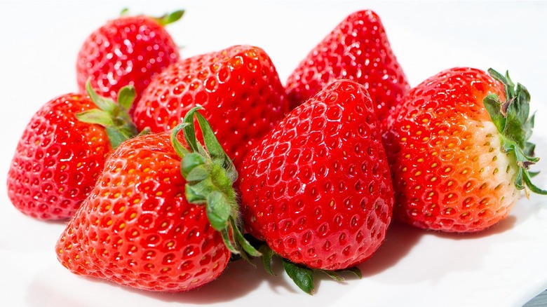 Pile of perfectly ripe strawberries on white background