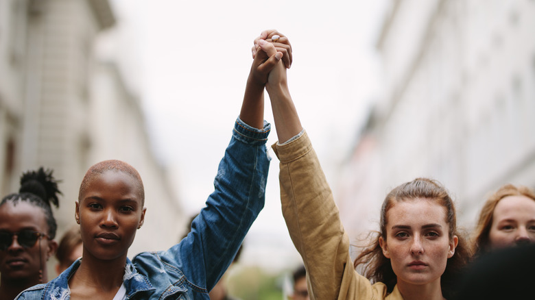 Two women holding hands, arms raised