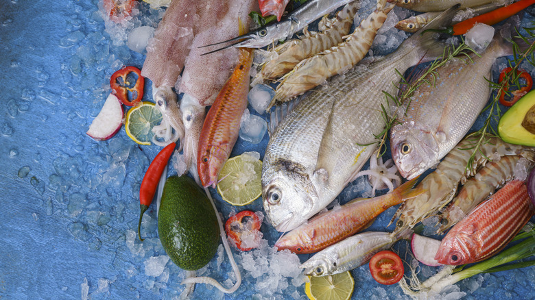 Whole fish and shellfish with peppers, lemons, and ice