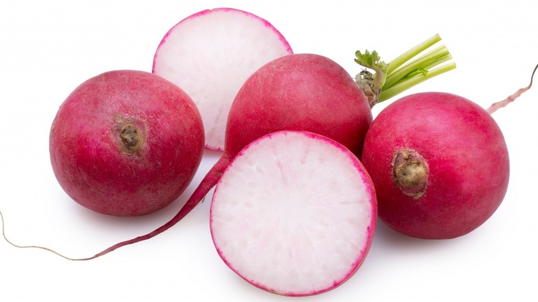 a selection of of whole and sliced radishes. 