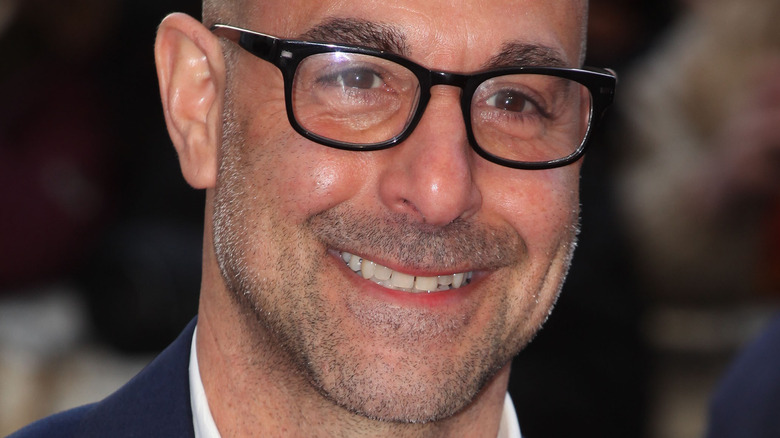 Stanley Tucci with glasses and wide smile