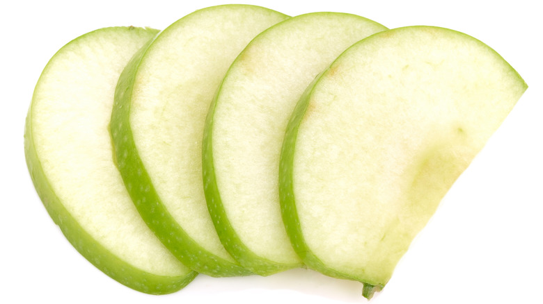 green apple slices on white background