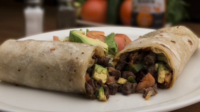 burrito on a plate with avocado slices