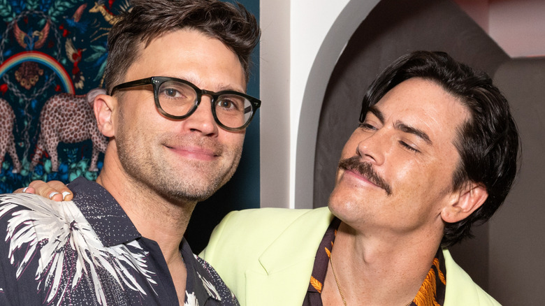 Tom Schwartz and Tom Sandoval pose near colorful wallpaper at Schwartz & Sandy's