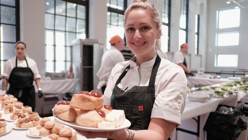 Top Chef contestant holding plate of desserts