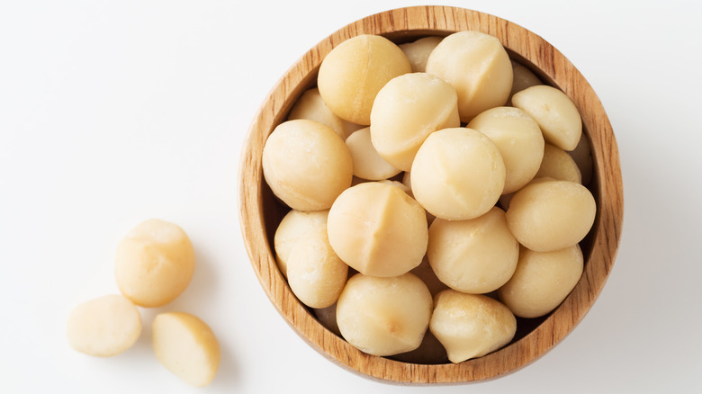 Shelled macadamia nuts in wooden bowl