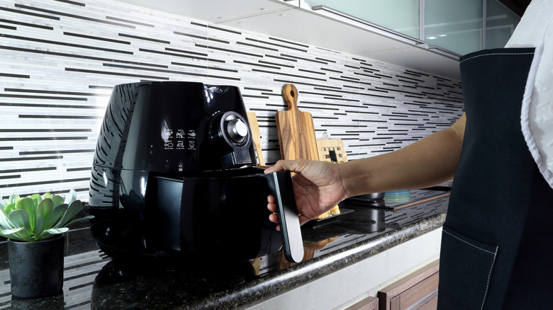 Person using air fryer