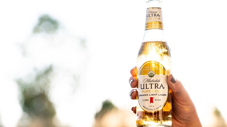 A bottle of Michelob ULTRA held up to the sunlight