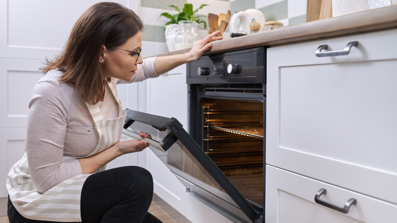 person looking into dirty oven