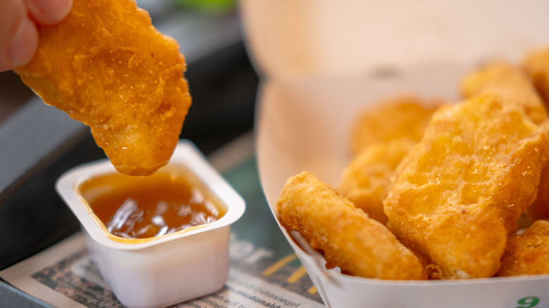 person dipping McDonald's chicken nuggets into sauce